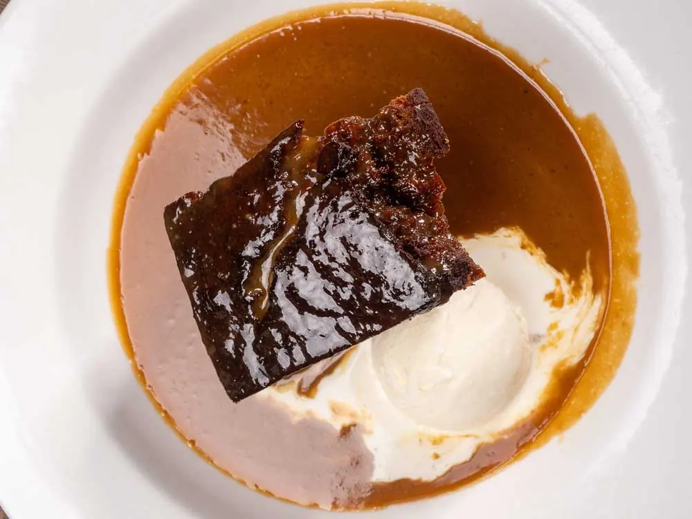 A sticky pudding with ice cream