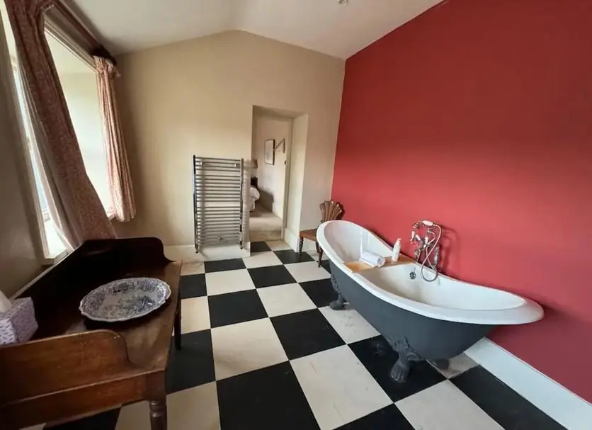 A roll-top bath on a chequered floor
