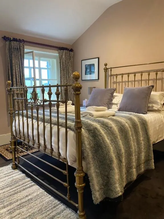 A brass bed in one of our en-suite rooms